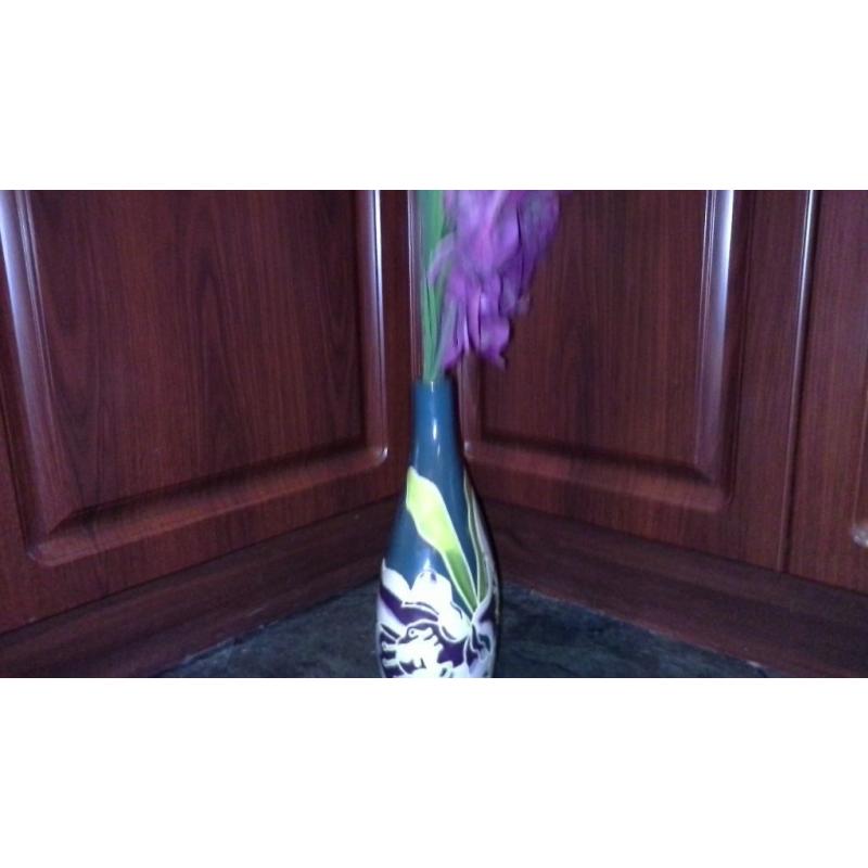 Unusual shape green flowery vase with plummy flowers.