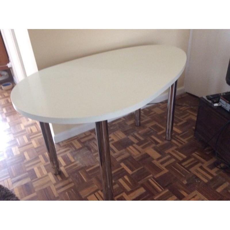 Oval-shaped white desk with chrome adjustable height legs