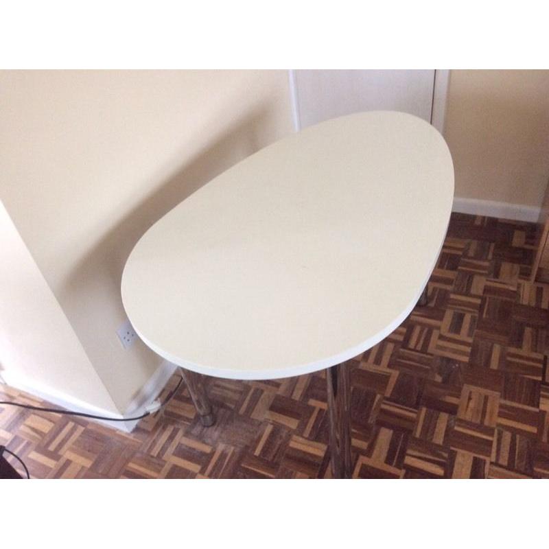 Oval-shaped white desk with chrome adjustable height legs