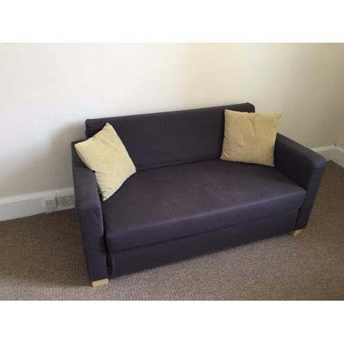 Blue IKEA sofa-bed with two matching yellow cushions and top mattress