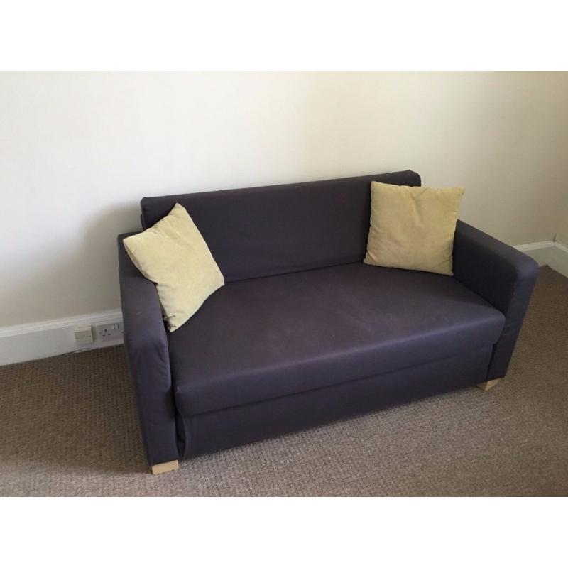 Blue IKEA sofa-bed with two matching yellow cushions and top mattress