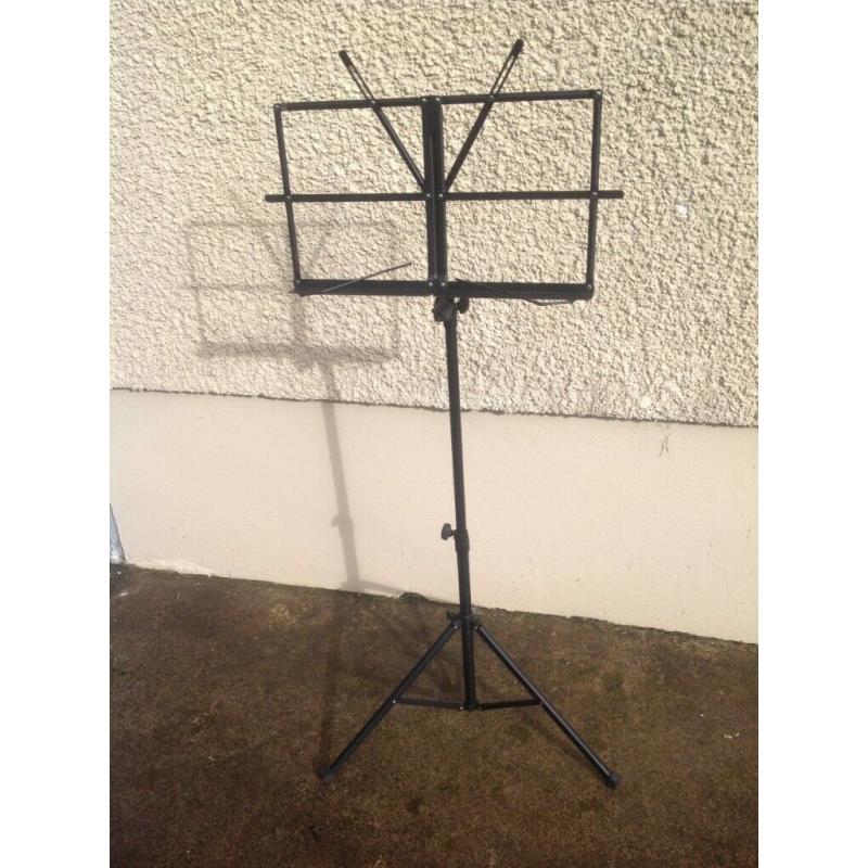 Foldable & adjustable music stand, black metal, for holding sheet music / books in place.